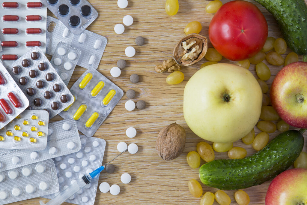 Pills and drugs next to healthy foods