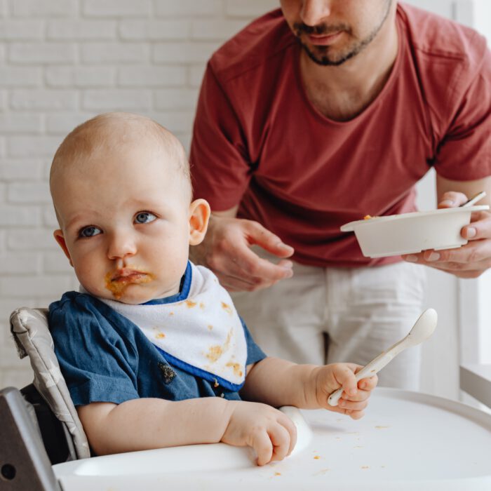 A parent feeding a fussy baby