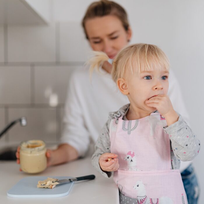 A parent helping their child with a snack